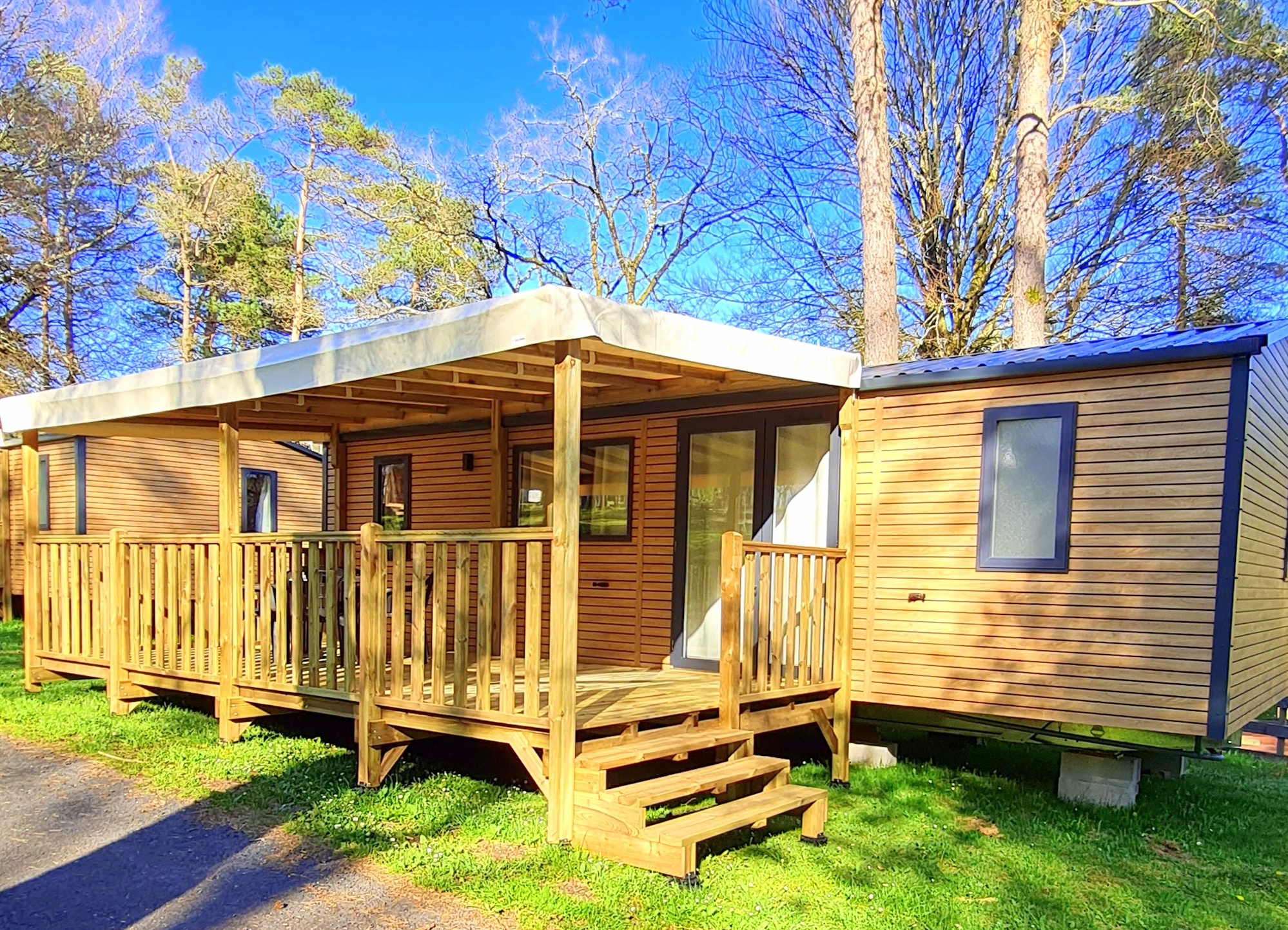 Mobil-home supérieur 3 chambres avec grande terrasse couverte au camping Les Trois Sources, hébergement familial et confort en pleine nature.