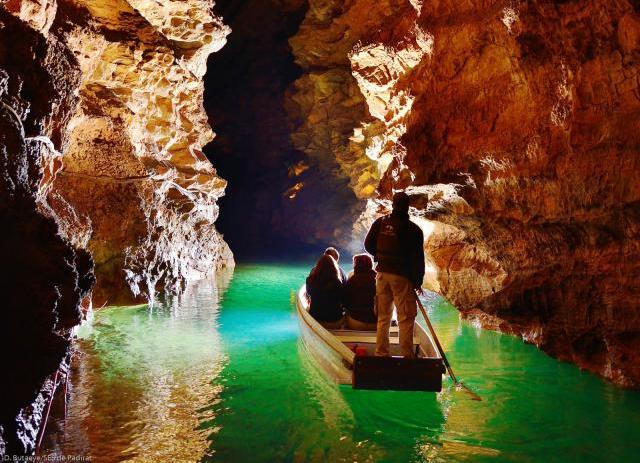 Intérieur du gouffre de Padirac avec un batelier guidant des touristes sur la rivière souterraine, visite touristique emblématique dans le Lot.