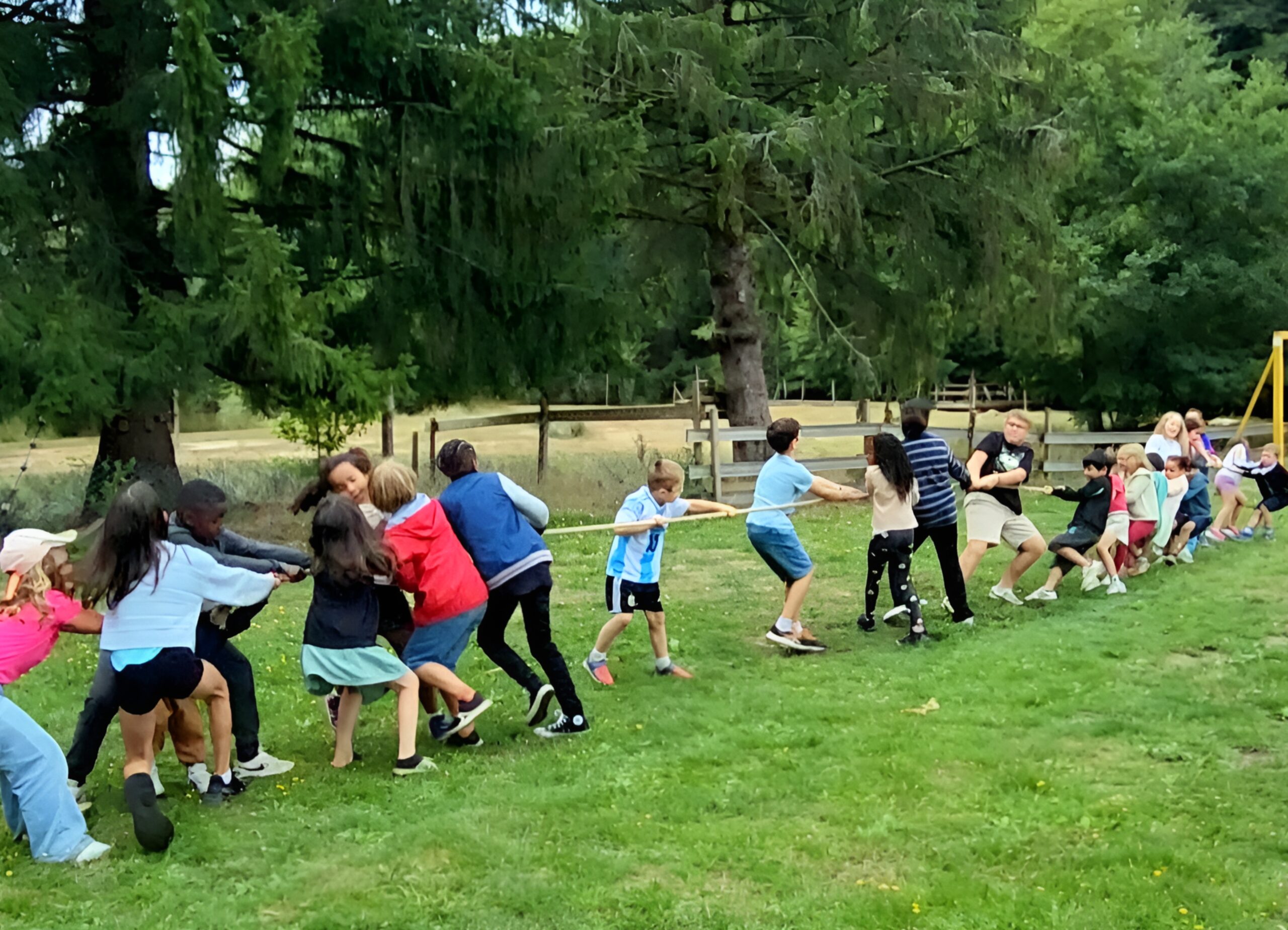 club enfant Enfants participant à un jeu de tir à la corde au Club Enfant du camping Les Trois Sources dans le Lot, région Occitanie, activité ludique et familiale.